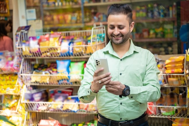man in convenience store using mobile ordering app