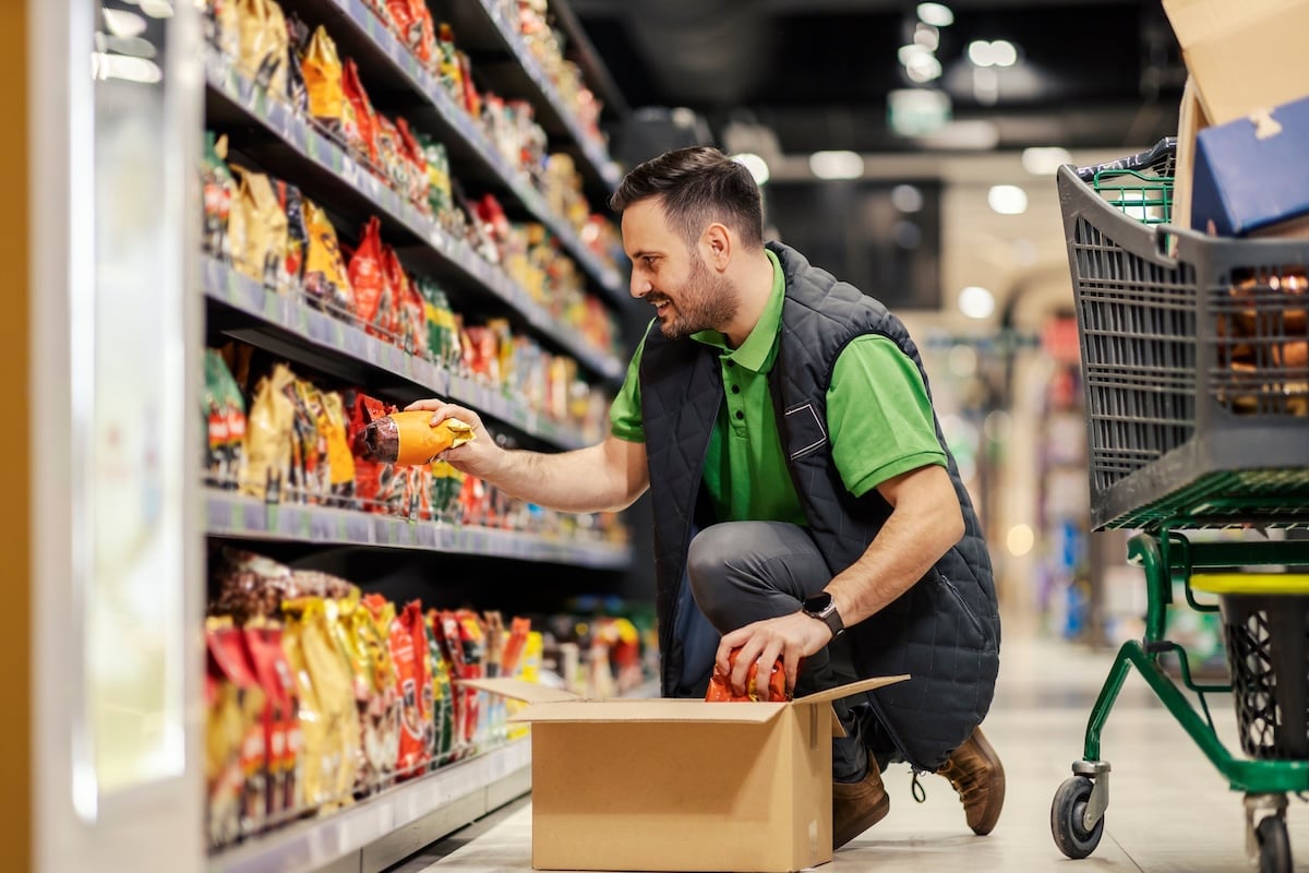 male grocery distribution professional putting items on shelf