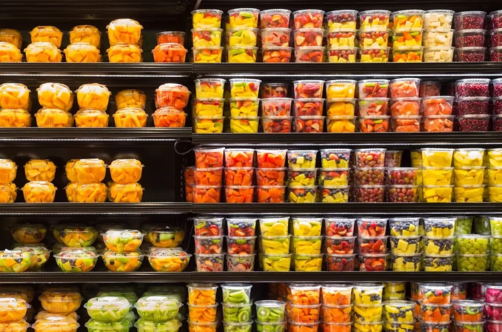 Grocery display of pre cut fruits and vegetables in containers image