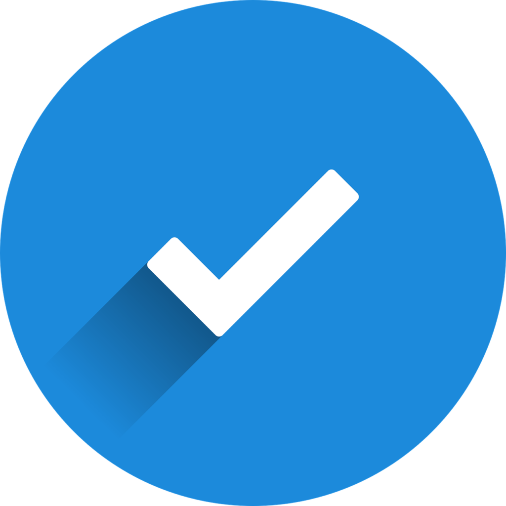 A white checkmark symbol with a subtle shadow centered within a solid blue circle against a transparent background